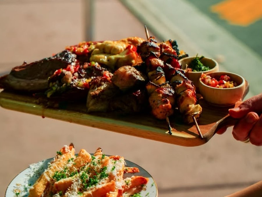 Traditional Argentine mixed grill board with a grilled chicken brochette, served with Parmesan and parsley fries