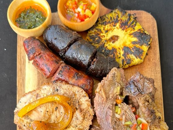 Traditional mixed grill board with flank steak, chorizo, morcilla, pork loin and grilled pineapple