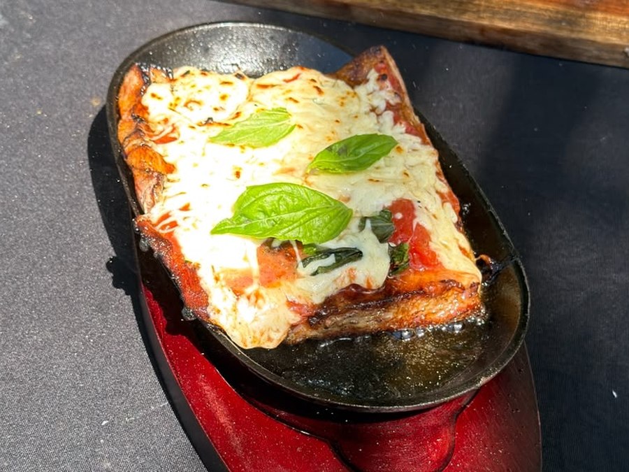 Pizza-style grilled pork matambrito topped with pomodoro sauce, melted mozzarella and fresh basil