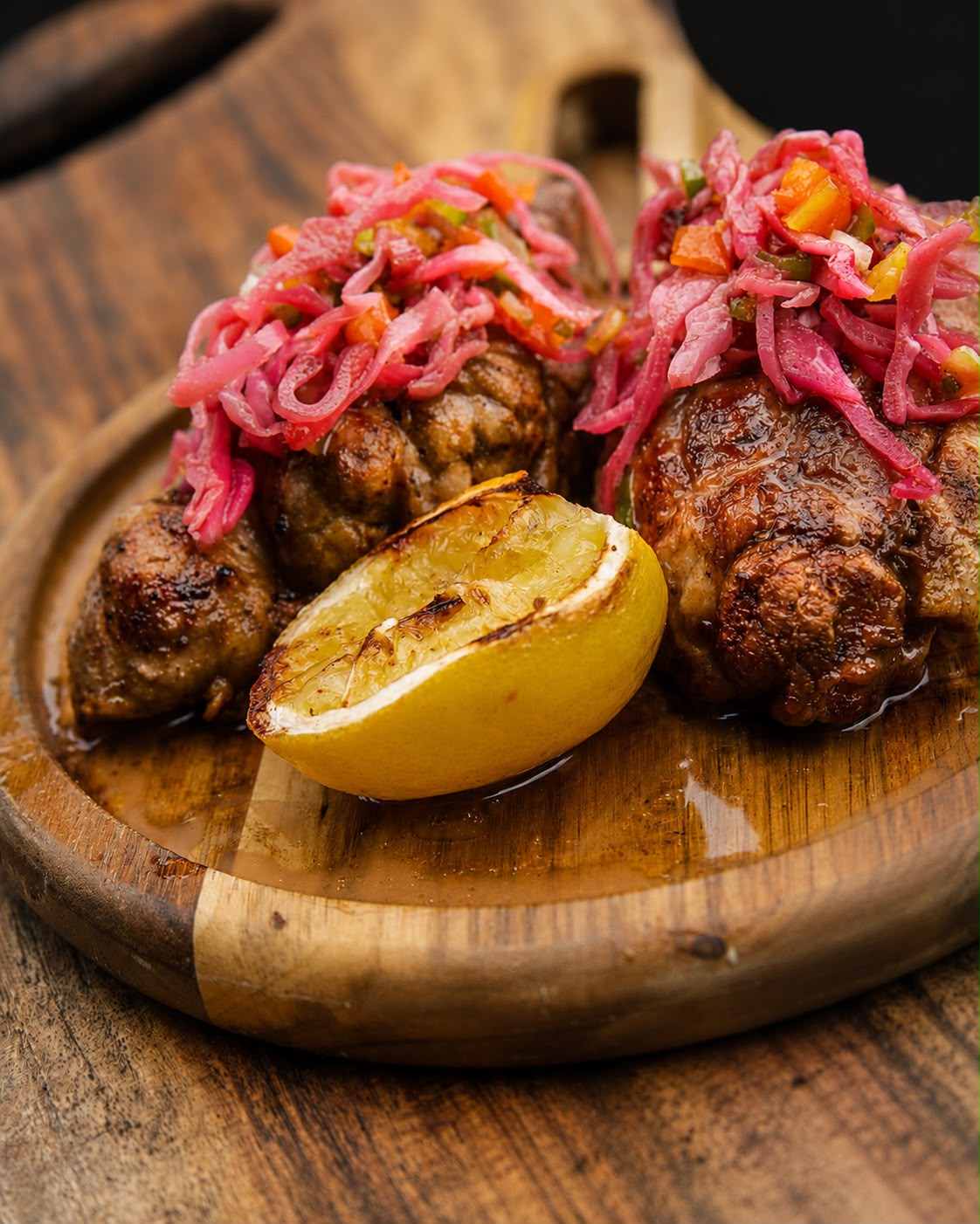 Argentine grilled beef sweetbreads topped with pickled red cabbage, served with charred lemon